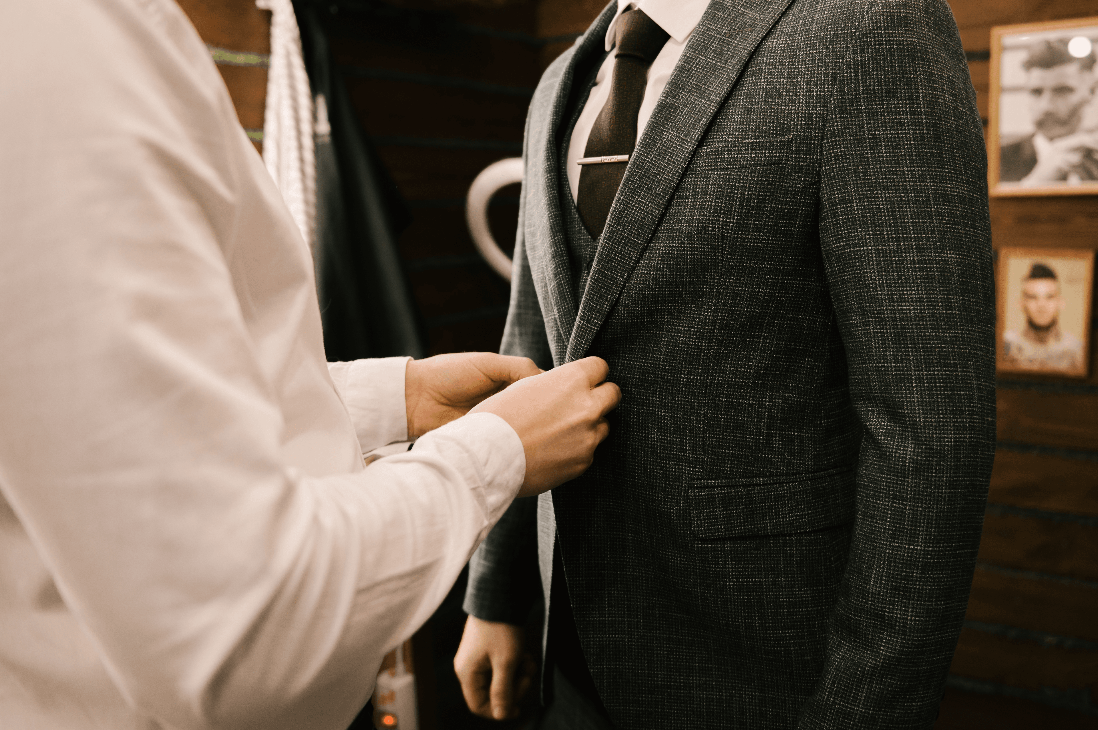 Tailor adjusting the jacket balance during a baste fitting