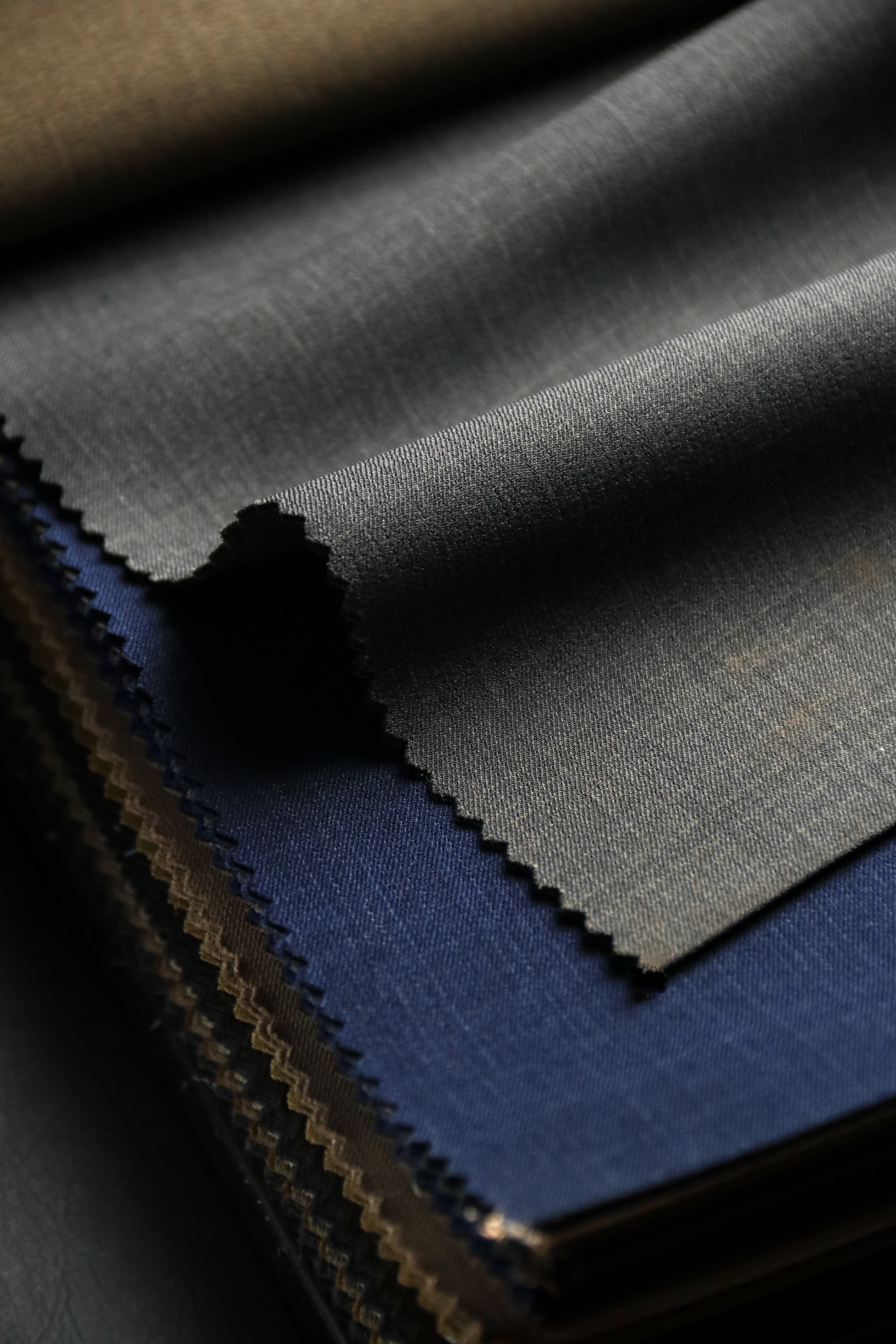 Close-up of fine charcoal herringbone and textured Irish and Italian linen cloth