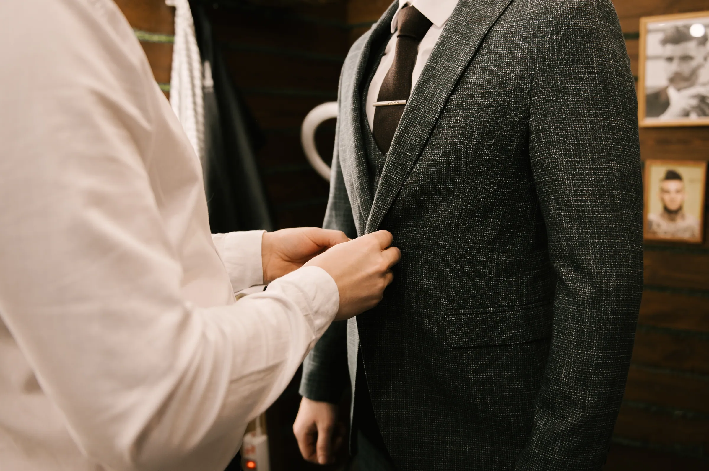 Tailor adjusting the jacket balance during a baste fitting